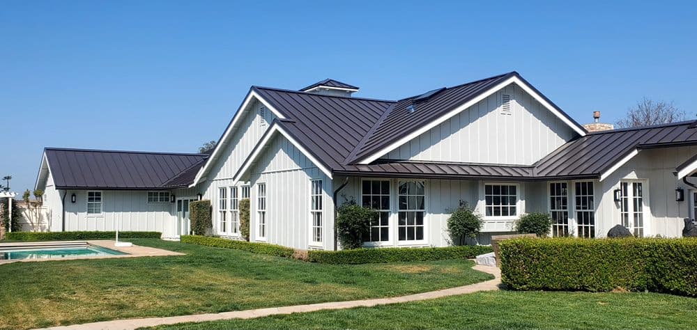Dark standing-seam metal roof on a modern farmhouse